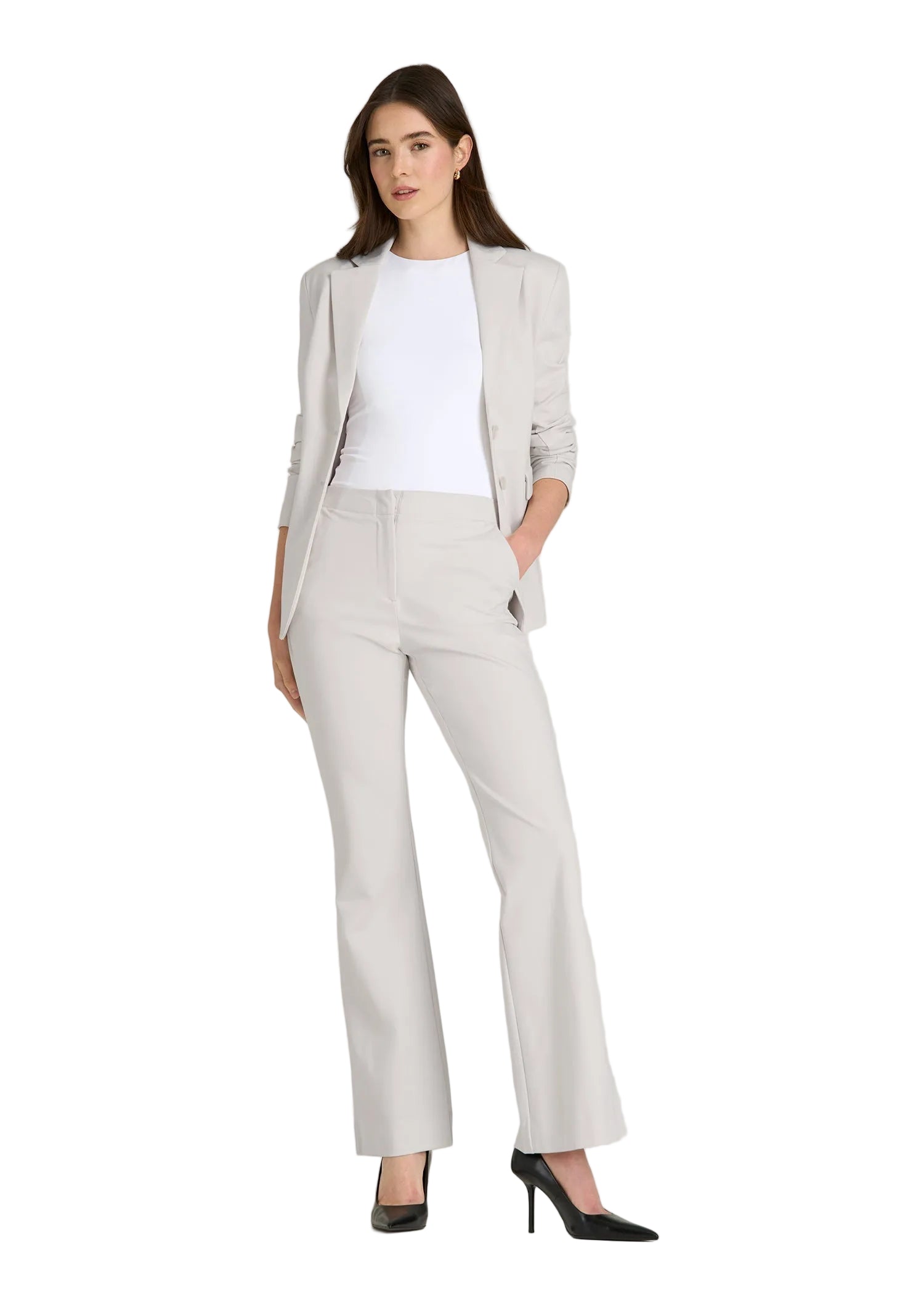 Woman wearing a light gray suit with a white shirt on a plain background