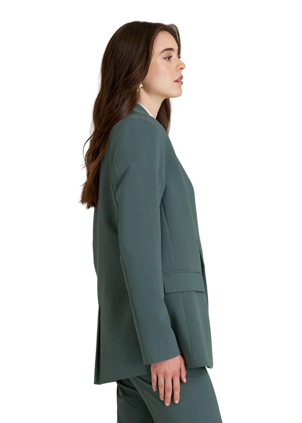 Woman wearing a teal coat on a light gray background